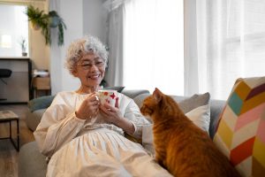 Grand mère avec son chat calme avec boîte à clés et téléassistance