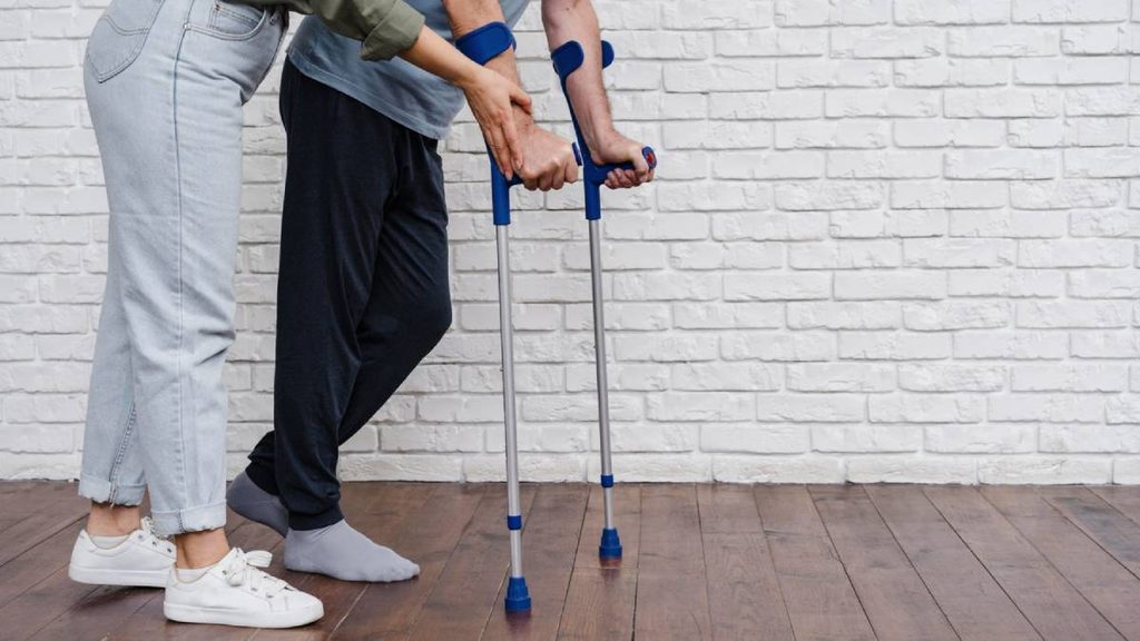 Personne âgée avec une béquille en rééducation après une fracture du fémur